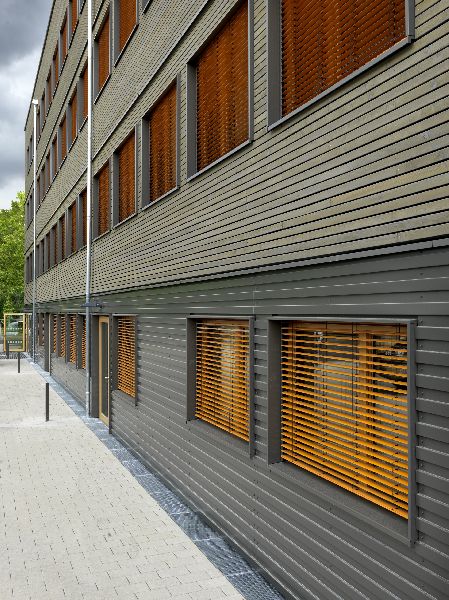 Fassade verkleidet mit Rhombusleisten und gekanten Aluminiumblech mit orangen Sonnenschutz (Quelle: Bernd Borchardt)